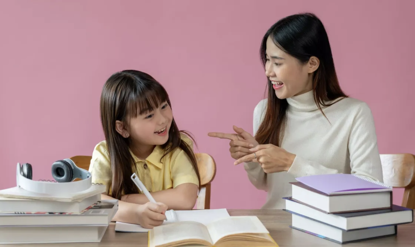 Un enfant qui fait ses devoir avec une adulte