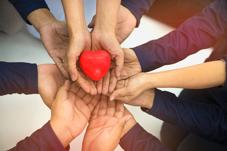 Plusieurs mains tendant un coeur
